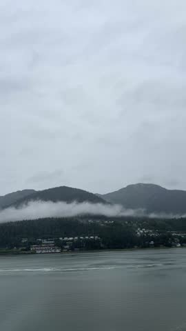 Foggy coastal town and mountains in Alaska with calm ocean

Scenic view of a coastal town in Alaska with fog rolling over green mountains, pine forest, and calm ocean waters on an overcast day