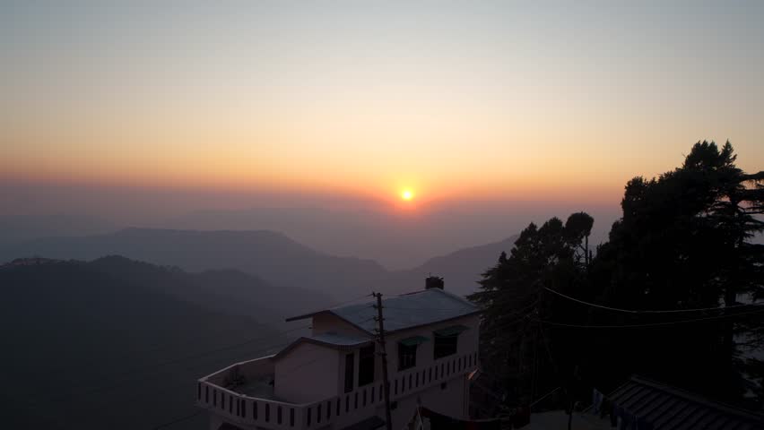 A scenic view of a golden sunrise over the Himalayan mountain range in Chakrata, Dehradun, Uttarakhand.