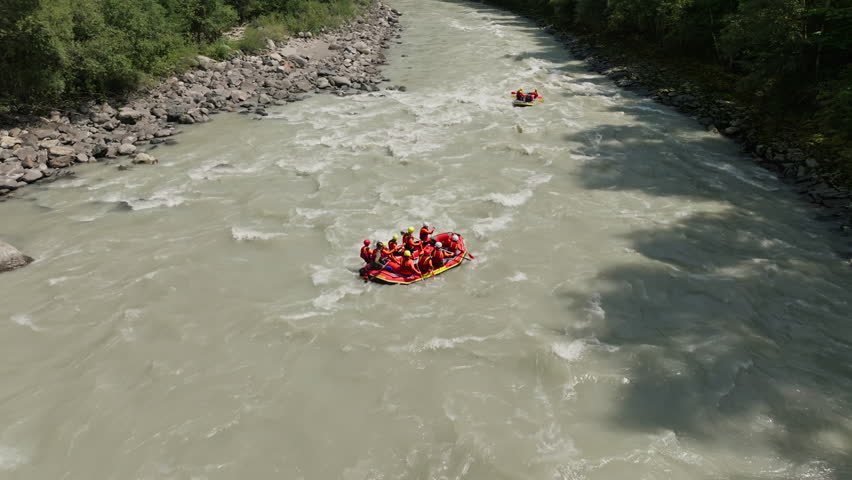 Drone view of whitewater rafting adventure in the Austrian Alps featuring inflatable raft on a fast flowing mountain river in Tyrol
