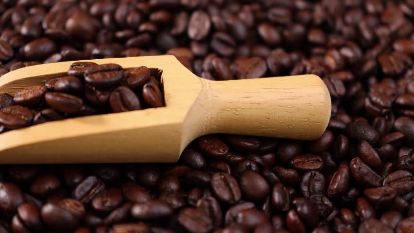 Roasted coffee beans in a wooden scoop	