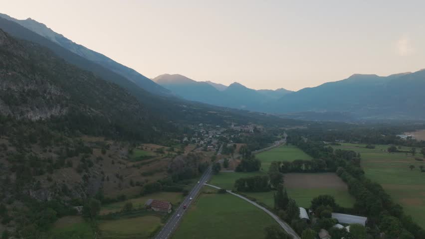 Cinematic aerial drone footage of the French Alps showcasing breathtaking mountain landscapes, dramatic peaks, lush green valleys, dense forests, and pristine alpine nature. Stunning panoramic views c