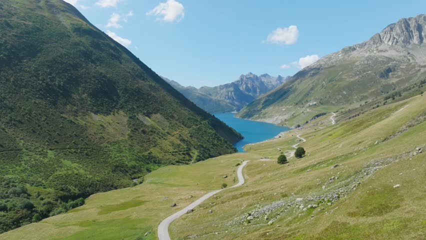Cinematic aerial drone footage of the French Alps showcasing breathtaking mountain landscapes, dramatic peaks, lush green valleys, dense forests, and pristine alpine nature. Stunning panoramic views c