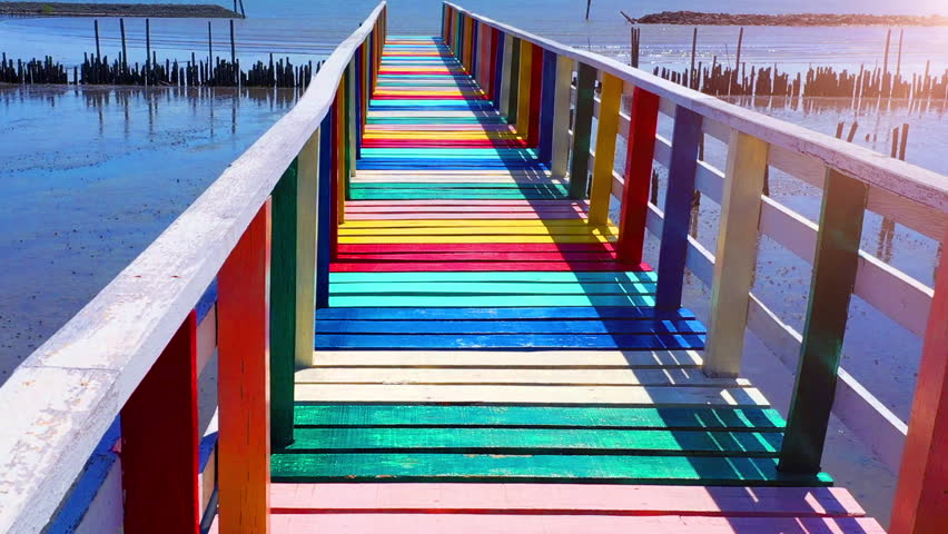 Rainbow bridge in Thailand.View of The colorful wood bridge extends into the sea under blue sky at samut sakhon province,Thailand