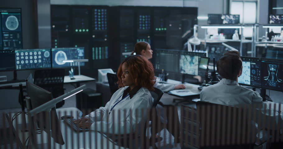 Team of Scientists work on Computers in an Advanced Medical Research Laboratory, Examining Brain Scans, Molecular Structures With AI Technology to Accelerate Drug Development and Disease Treatment.