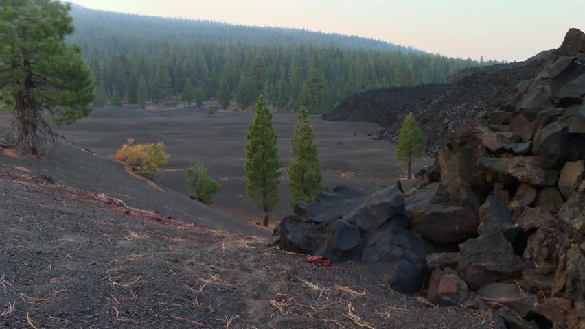Volcanic terrain with black sand and lava rocks at the Fantastic Lava Beds in Lassen Volcanic National Park, California