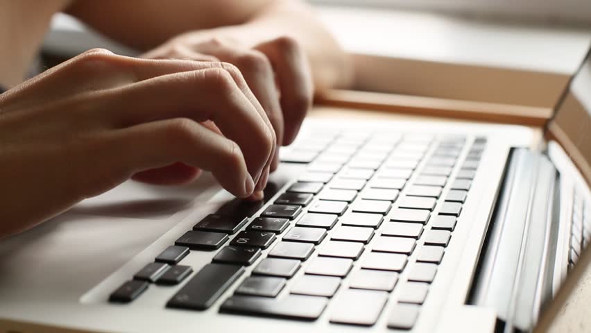 Close-up of a young woman typing on a laptop keyboard (HD)