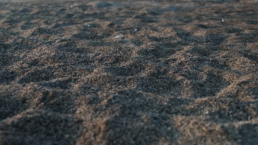 Close-up shot of dark ocean waves crashing against a rocky shore.