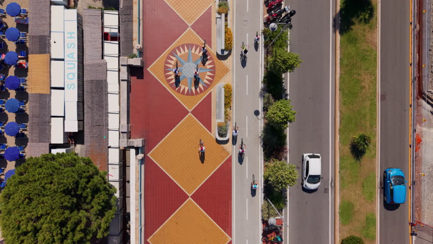 Aerial view of cyclists riding along Corso Italia near the Mediterranean coast in Genoa