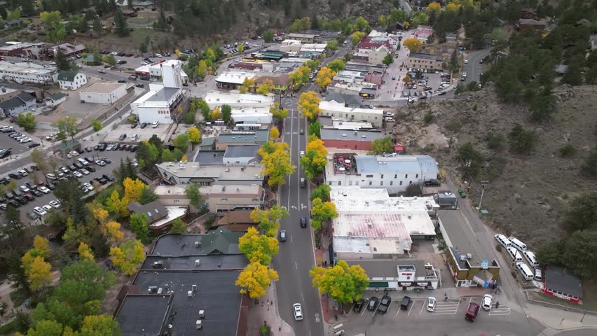 Panoramic aerial view of Elkhorn Avenue in downtown Estes Park, Colorado town with fall foliage colors and gateway to Rocky Mountain National Park landscapes during the autumn season - 4K Drone