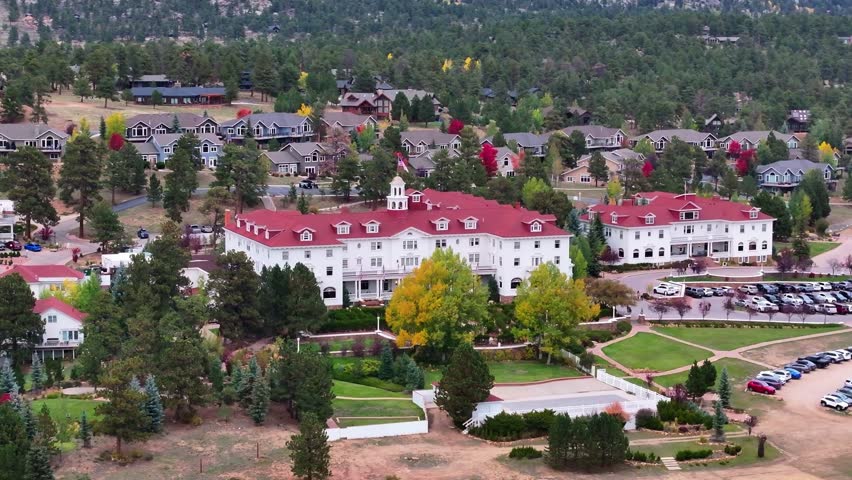 Panoramic aerial view of the historic Stanley Hotel in Estes Park, Colorado town with fall foliage colors and gateway to Rocky Mountain National Park landscapes during the autumn season - 4K Drone