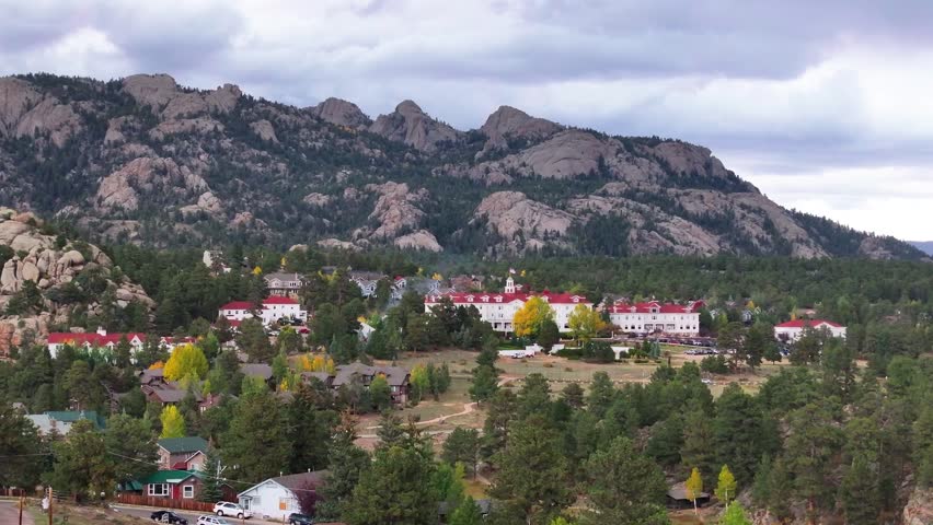 Aerial view of the historic Stanley Hotel in Estes Park, Colorado town with fall foliage colors and gateway to Rocky Mountain National Park landscapes during the autumn season - 4K Drone