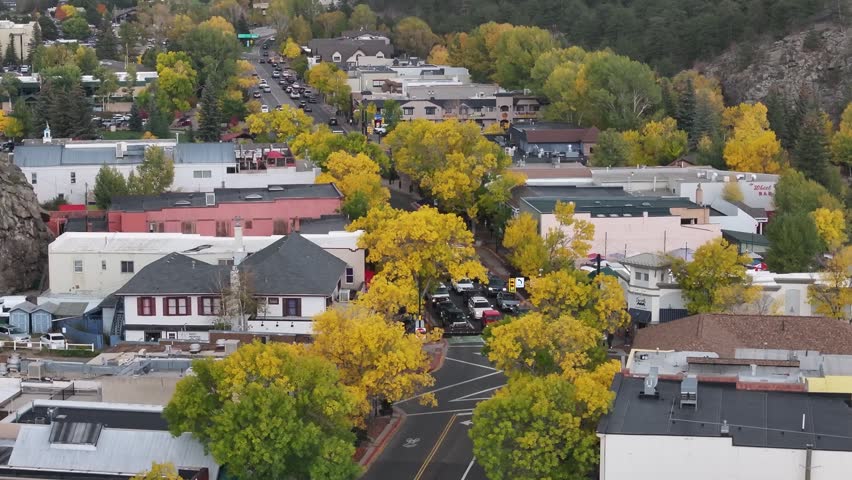 Aerial view of Elkhorn Avenue in downtown Estes Park, Colorado town with fall foliage colors and gateway to Rocky Mountain National Park landscapes during the autumn season - 4K Drone