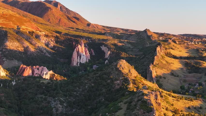 Panoramic aerial view of Garden of the Gods state park rock formation landscapes with sunrise alpenglow light during autumn season in Colorado Springs, Colorado with surrounding mountains - 4K Drone