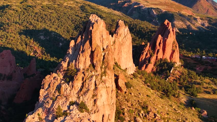 Aerial view of Garden of the Gods state park rock formation landscapes with sunrise alpenglow light during autumn season in Colorado Springs, Colorado with mountains in background - 4K Drone