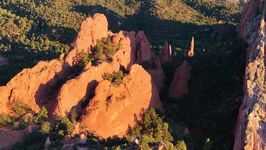 Aerial view of Garden of the Gods rock formation landscapes with sunrise alpenglow light during autumn season in Colorado Springs, Colorado with mountains in background - 4K Drone