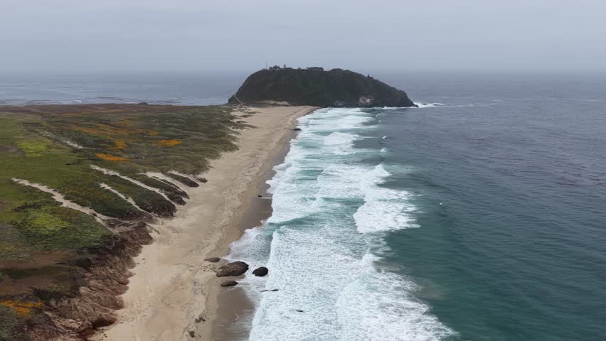 Aerial view of Point Sur Lighthouse on a rocky headland along the Big Sur coastline in California