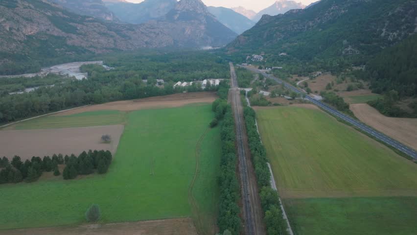 Cinematic aerial drone footage of the French Alps showcasing breathtaking mountain landscapes, dramatic peaks, lush green valleys, dense forests, and pristine alpine nature. Stunning panoramic views c