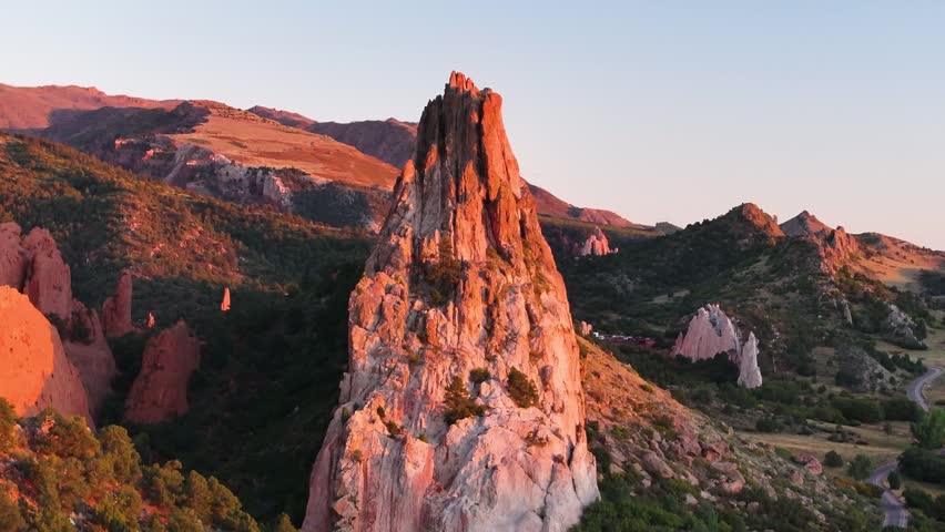 Aerial view of Garden of the Gods rock formation landscapes with sunrise alpenglow light during autumn season in Colorado Springs, Colorado park with mountains in background.
