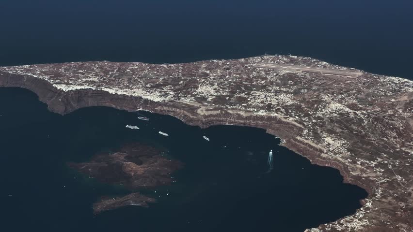 flying along central part of Santorini, a famous Greek Island in the southern Aegean Sea with Thira the capital of Santorini, with Ormos Firon as well as Cruise Ships anchored close to cliffy coastline - 4k aerial video footage 