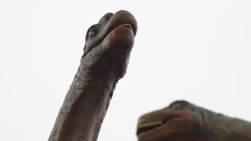 Dinosaur animated animatronic sculpture with open jaws against bright overcast sky at Pairi Daiza park