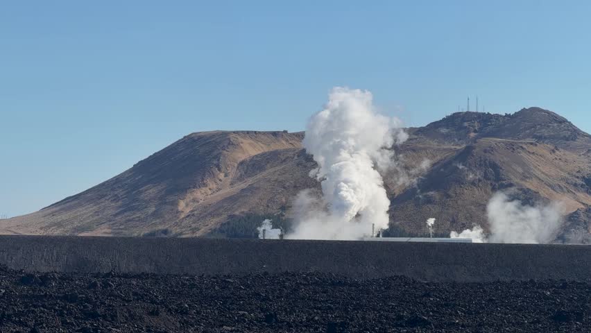 Steam rises from the Svartsengi Geothermal Power Station in Iceland, highlighting renewable energy production within a dramatic volcanic landscape.
