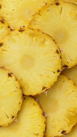 Sliced pineapple fruit. rotating food. Vertical footage