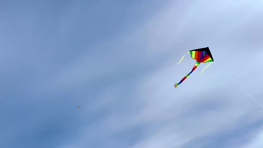 Colorful kite flying high in blue sky
