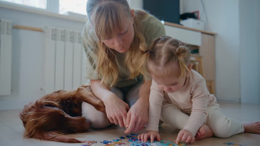 Mother and child puzzle together on floor. Dog lies nearby, relaxed and calm. Warm, cozy indoor setting with soft lighting. Focus on bonding, patience, and early childhood development
