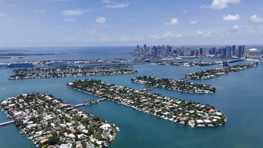 Aerial view of Miami skyline and waterfront islands over turquoise Biscayne Bay in sunny Florida, USA. g.
