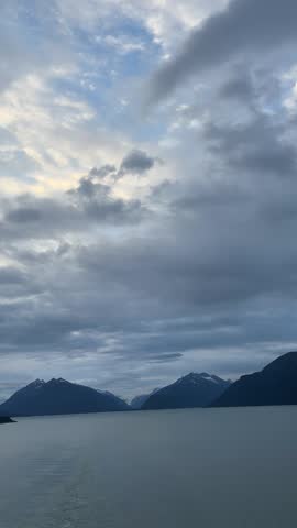 Dramatic Clouds Over Calm Bay and Snow Capped Mountains in Alaska

Beautiful landscape of calm water with snow capped mountains and dramatic cloudy sky in Alaska. Peaceful nature scene with soft light and blue tones.