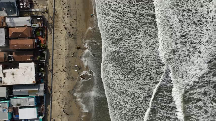 Straight down aerial view in vertical orientation of king tides at Pacific Beach in San Diego, California