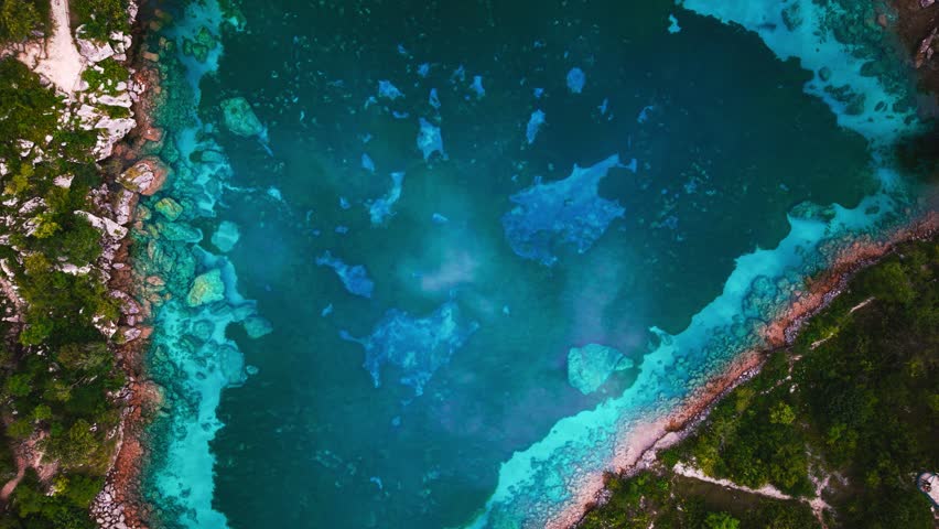 Clear water of Lago Cornino mountain lake with bright cyan borders in Friuli, Italy. Aerial top view