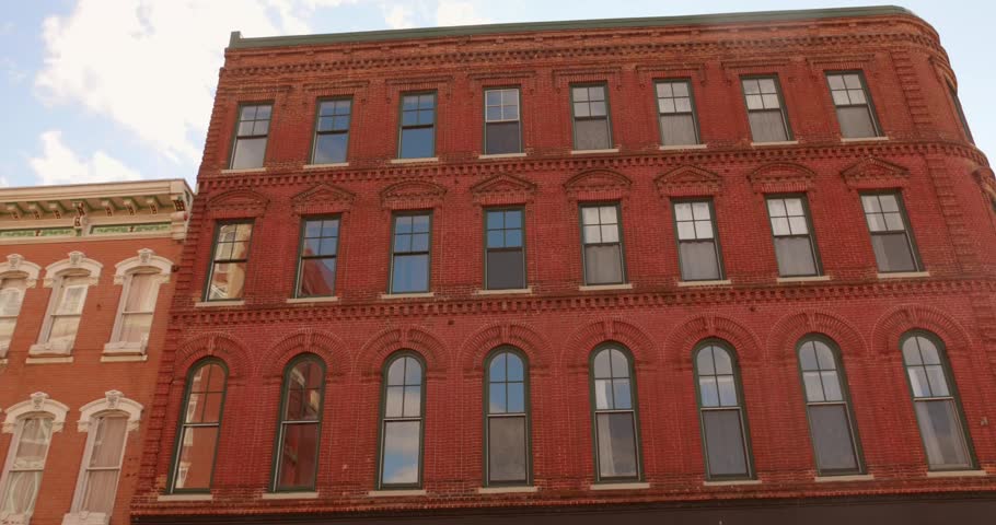 Historic red brick building facade in downtown Dubuque under a blue sky