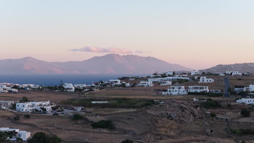 Cycladic architecture on Mykonos island, Greece during romantic sunset over Aegean Sea with Tinos and Delos islands in background, popular summer holiday destination