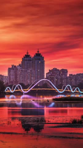 Beautiful colourful sunset over Obolon Embankment in Kyiv, Ukraine, calm reflections on the water, and a glowing city skyline in warm evening light.