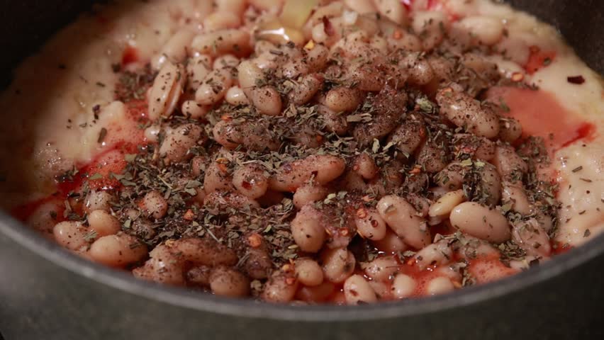 Simmering Hearty Homemade Bean Soup with Vegetables in Metal Pot on Cooktop