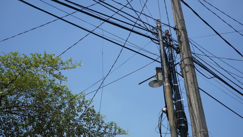 Utility Pole, Street Light and Overhead Power Lines Against Clear Blue Sky
