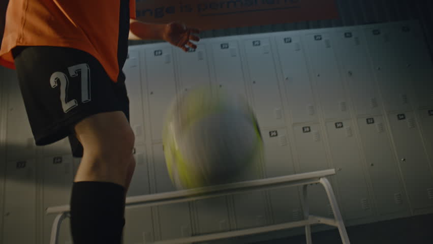 Young Footballer Refining Soccer Skills in Isolation Before Tournament. Dressed in Team Kit, Stays Laser Focused, Maneuvering Ball in Modern Stadium Dressing Facility. Discipline, Concentration.