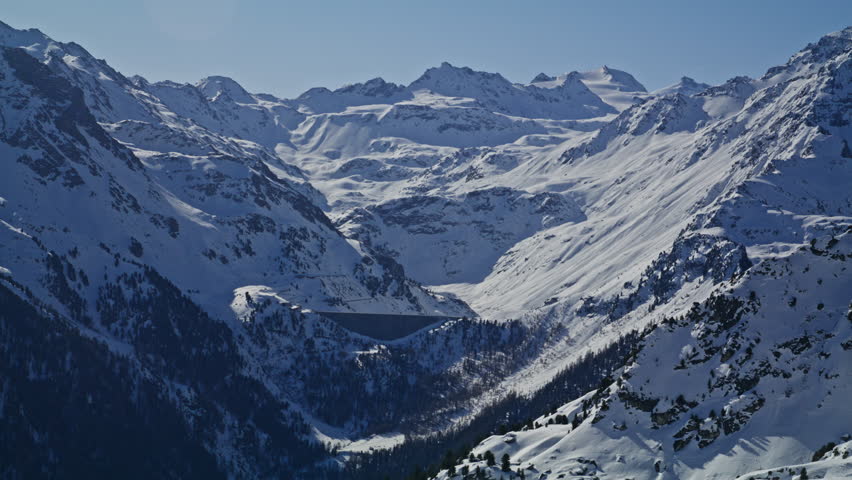 Scenic view of Cleuson Dam beneath Rosablanche in the Swiss Alps. Snow covered mountains, alpine reservoir and hydroelectric infrastructure represent renewable energy in Switzerland.