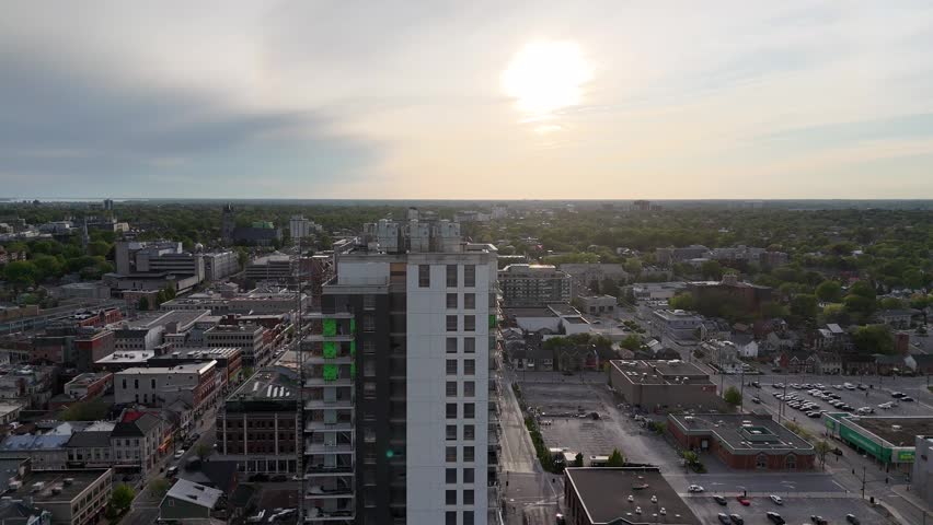 An aerial footage of new condos building with urban surroundings including river at sunset in Kingston, ontario, canada