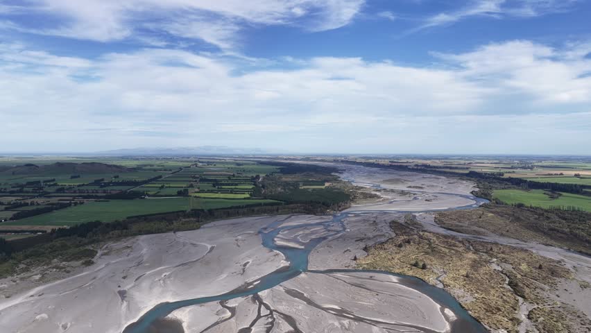 Aerial view of braided river across New Zealand South Island landscape.
Sunny drone panorama of pristine nature and winding waterways.