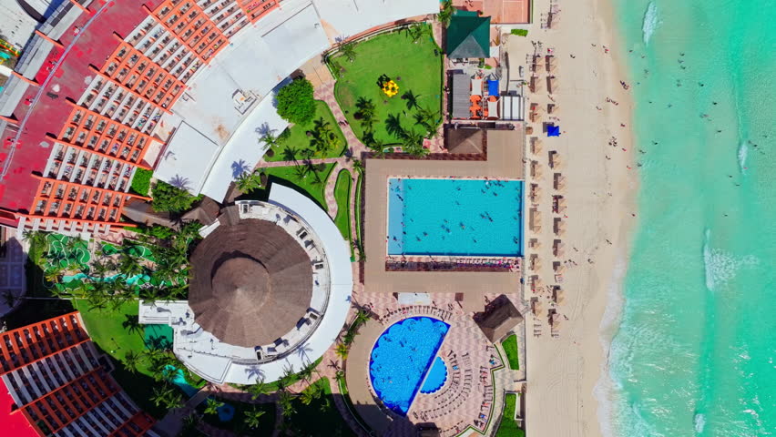 Close aerial view of a beach resort with a circular pool and terraces in the Cancun Hotel Zone, Quintana Roo, Mexico.