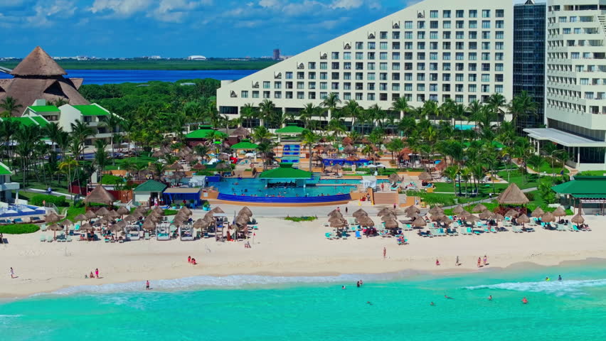 Aerial view of a pyramid-style resort with pools and lush gardens along the Cancun Hotel Zone beach, Quintana Roo, Mexico.