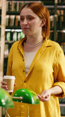 Vertical frame: A tutor in yellow speaks to university students gathered at library table, presenting shared study, mentoring and academic cooperation.