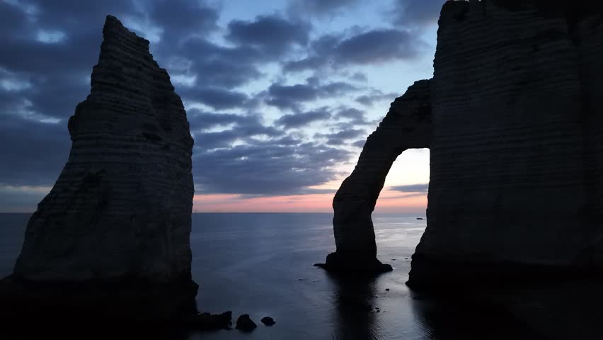 Etretat France chalk cliffs and natural arch at dusk