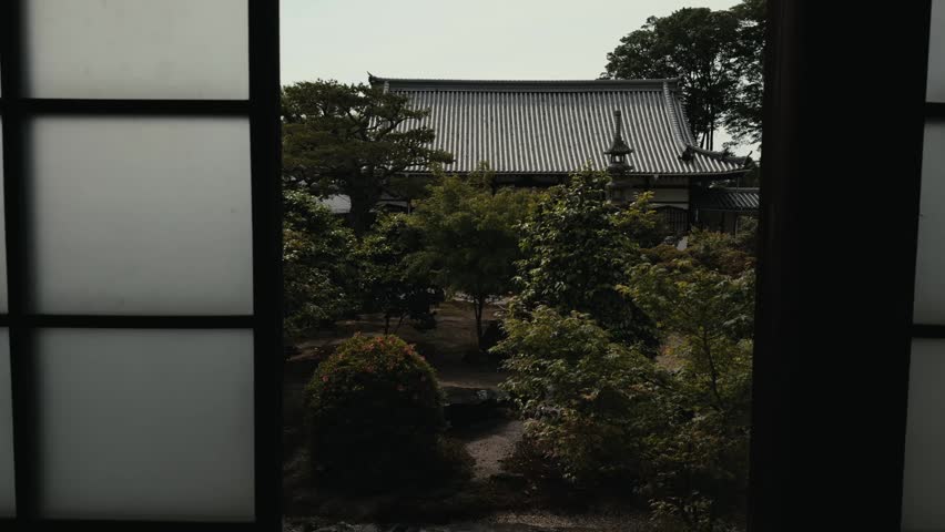 Interior view through a shoji doorway at Koshoji Temple in Uji, showing a peaceful Japanese garden, tiled roof, trees, and traditional architecture.