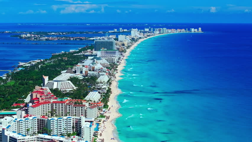 Aerial view of the Cancun Hotel Zone coastline, Quintana Roo, Mexico, deep-blue Caribbean Sea and turquoise shallows along the white-sand beach.
