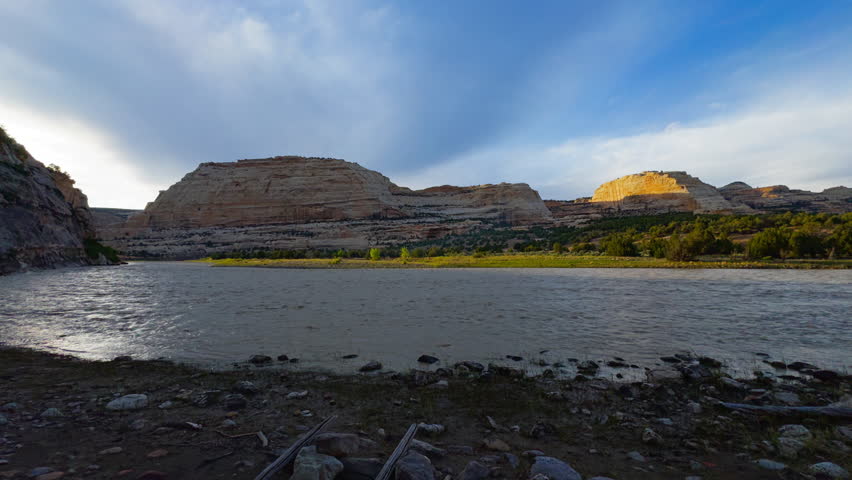 Harding Hole backcountry camping overlook spot, expansive river and canyon landscape with layered hills and sweeping cloud patterns, establishing pan right