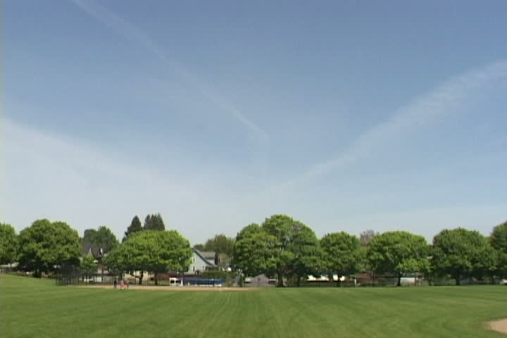 Time lapse at Portland Oregon park with people playing, traffic moving and jet