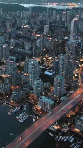Downtown of Vancouver at night, skyscrapers and traffic on the roads. 
